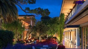 Een modern hotel met een binnenplaats, buiten zitplaatsen en een goed verlichte ingang.