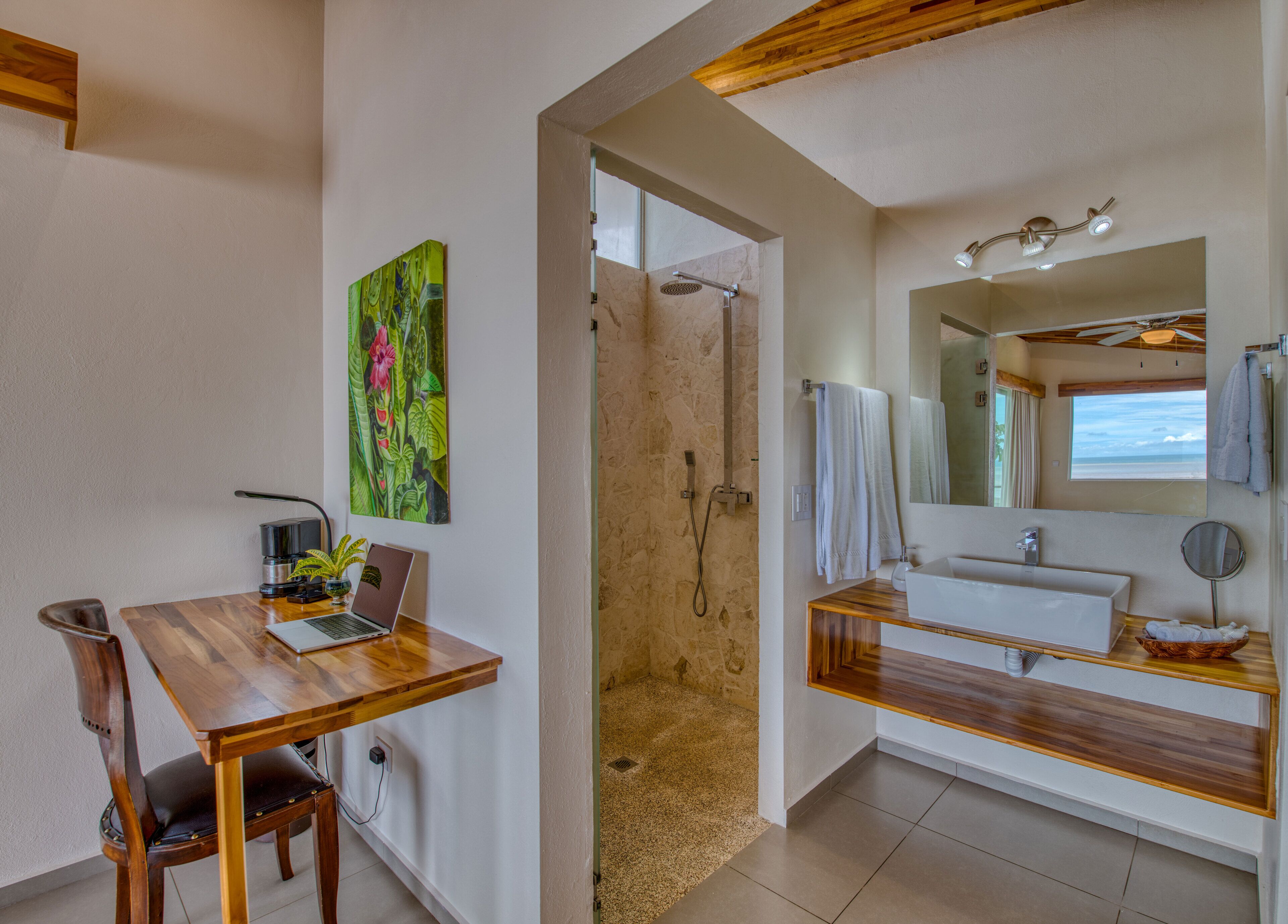 A bathroom with a shower, sink, and a wooden vanity.