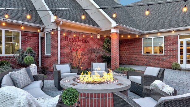 A patio area with a fire pit, outdoor seating, and string lights. - Residence Inn Woodbridge Edison/Raritan Center (Woodbridge)