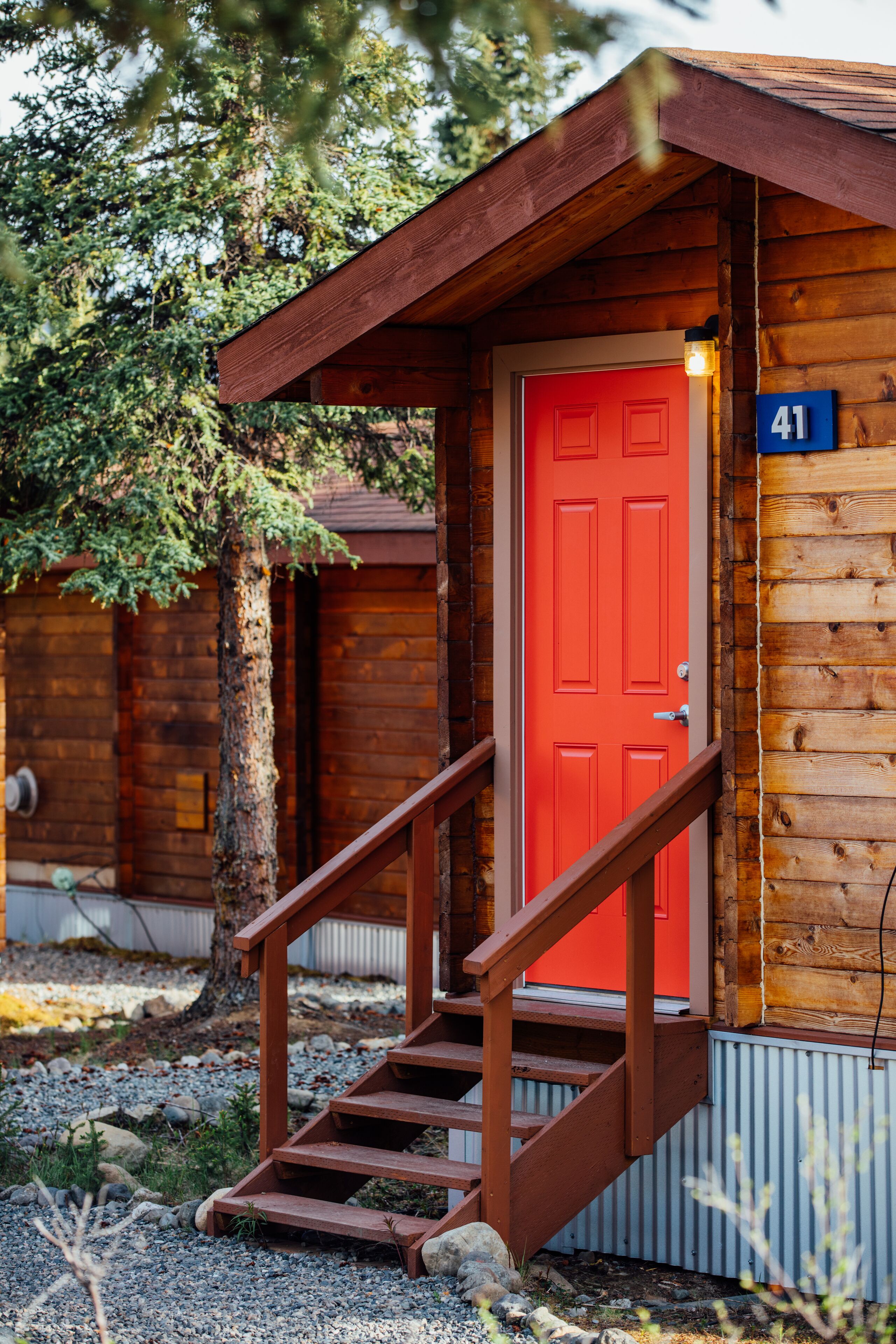 Une cabane en bois avec une porte rouge et une plaque portant le numéro 41.