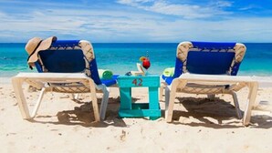 Two beach chairs facing a turquoise sea, with a small table between them. - Piscadera Harbour Village (Willemstad)