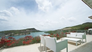 A terrace with white furniture overlooking a scenic coastal landscape. - Piscadera Harbour Village (Willemstad)