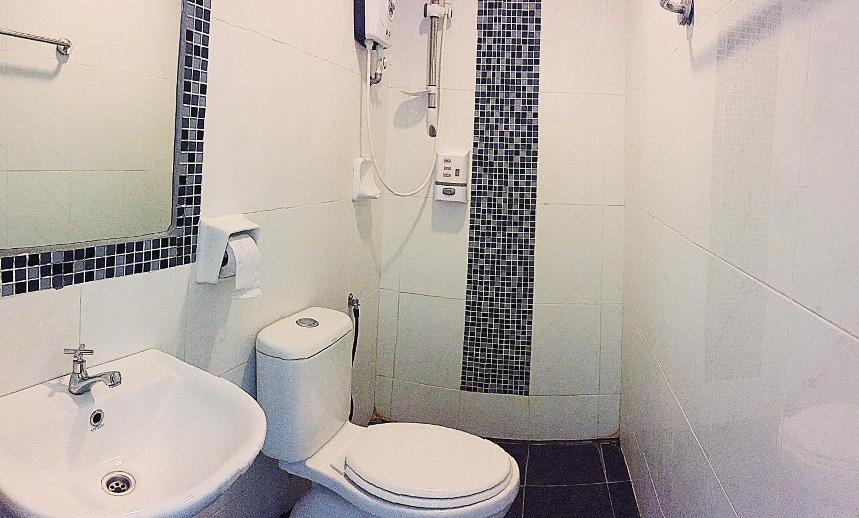 A bathroom with a sink, toilet, and shower.