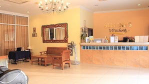A hotel reception area with a reception desk, a chandelier, a mirror, and seating arrangements. - Sun Inns Hotel Puchong (Puchong)