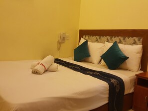 Une chambre d’hôtel équipée d’un lit, d’une table de chevet, d’un téléphone et d’un téléphone fixé au mur.