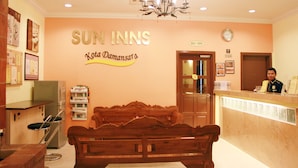 A reception area with a wooden bench, a reception desk, and a wall sign that reads "SUN INNS Kota Damansara." - Sun Inns Hotel Kota Damansara (Petaling Jaya)
