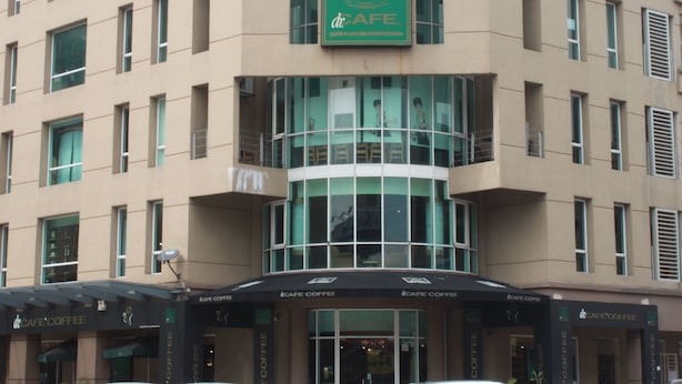 A multi-story building with a cafe coffee sign on the facade. - Sun Inns Hotel Kota Damansara (Petaling Jaya)