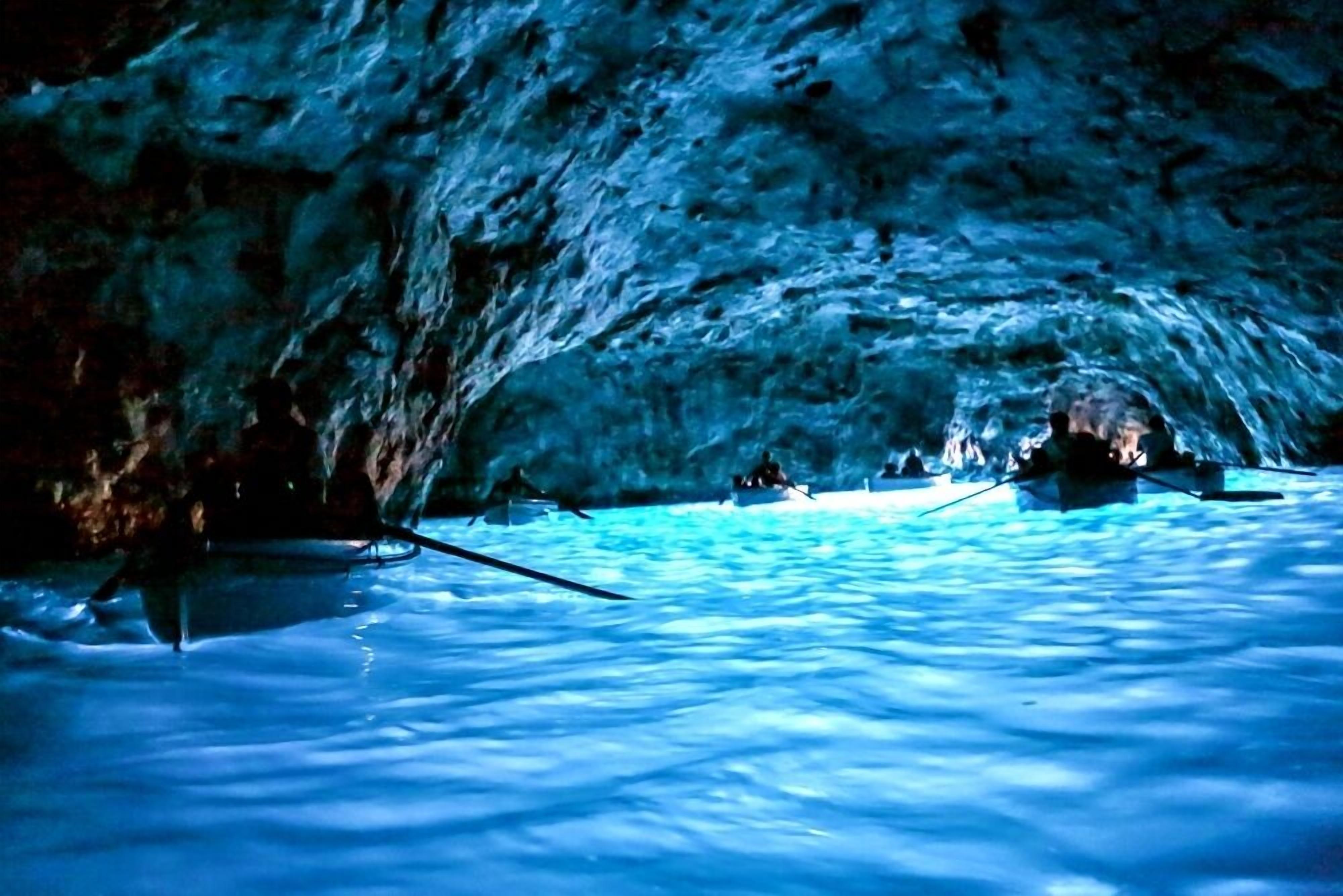 Una cueva con agua y barcos en su interior.