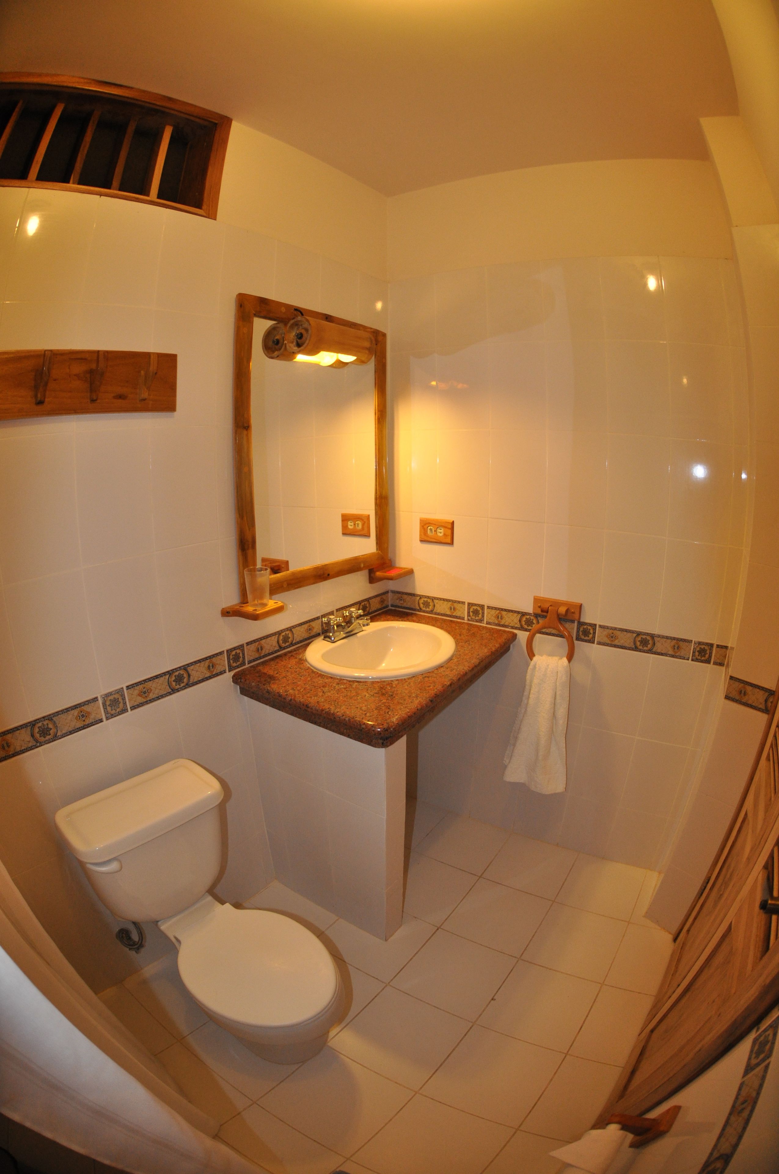Ein Badezimmer mit Toilette, Waschbecken und Spiegel.