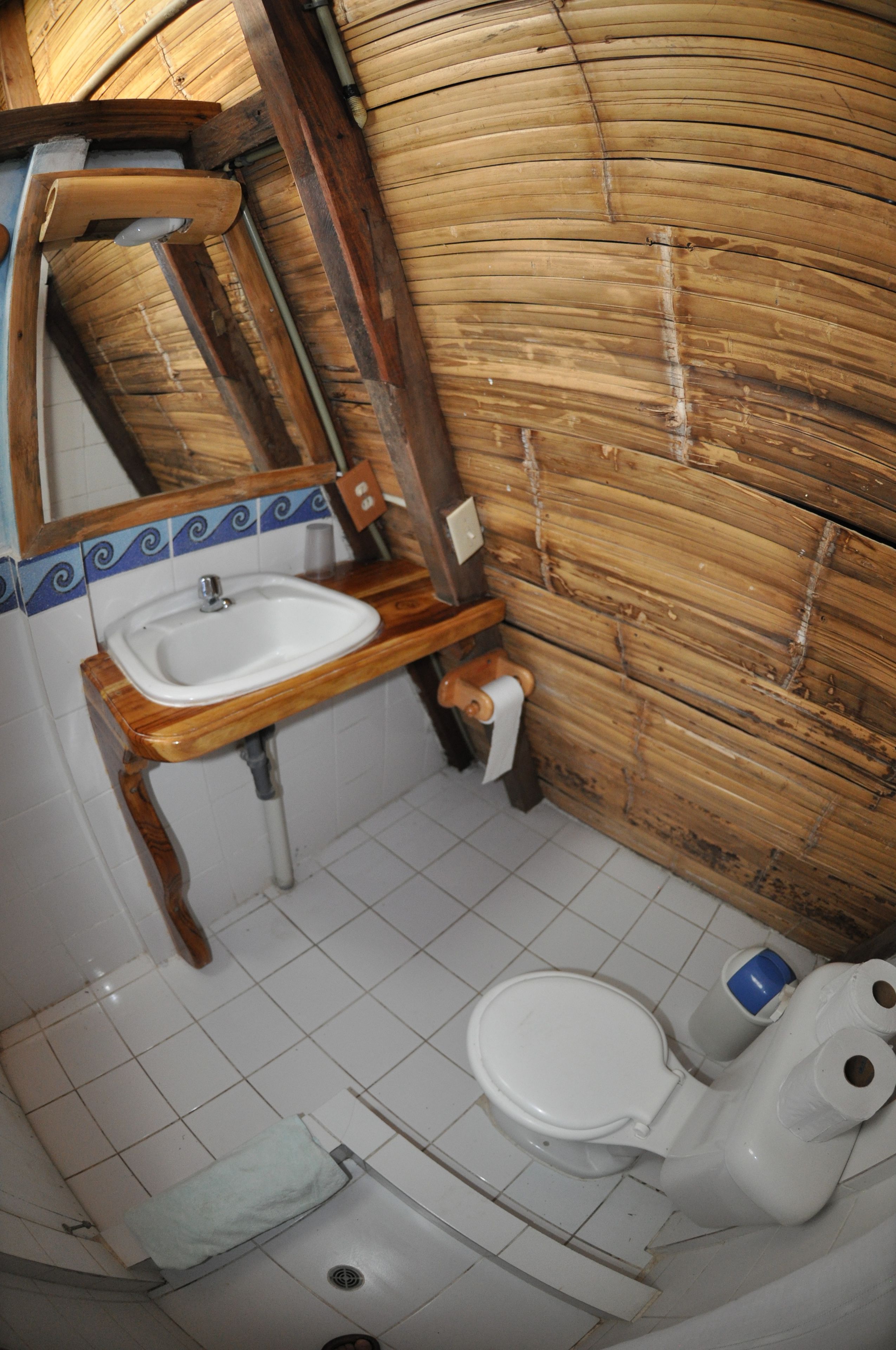A bathroom with a wooden vanity, a white sink, and a toilet.