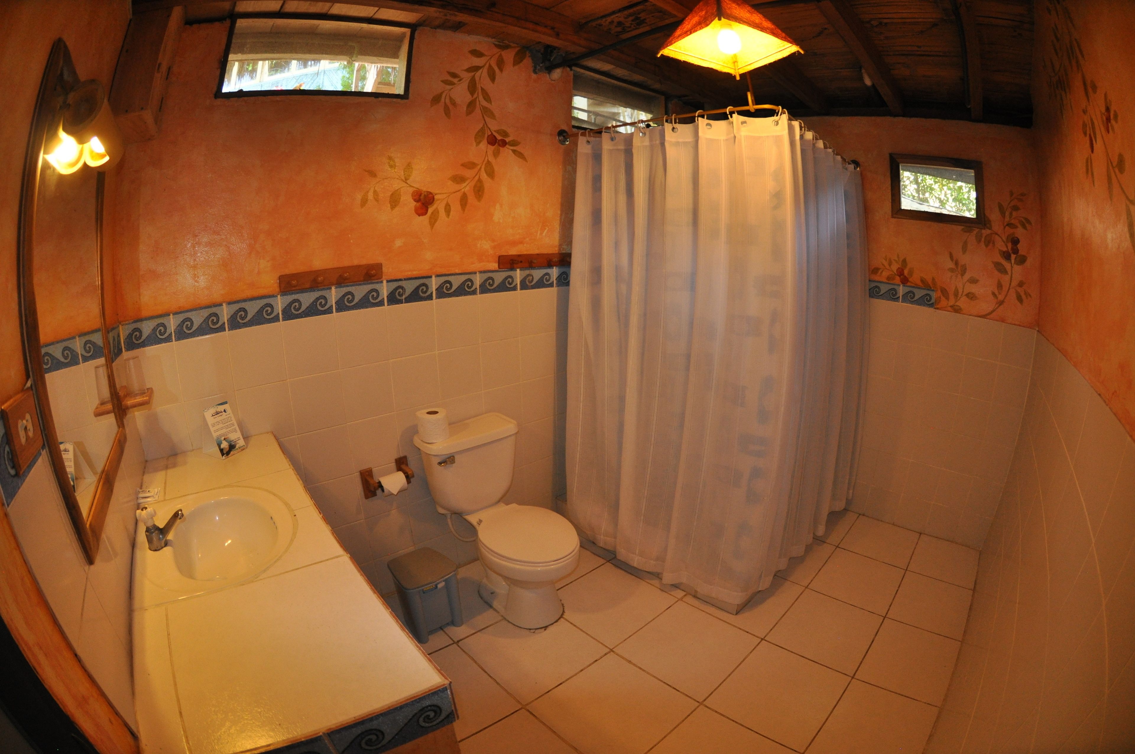 A bathroom with a sink, toilet, and shower curtain.