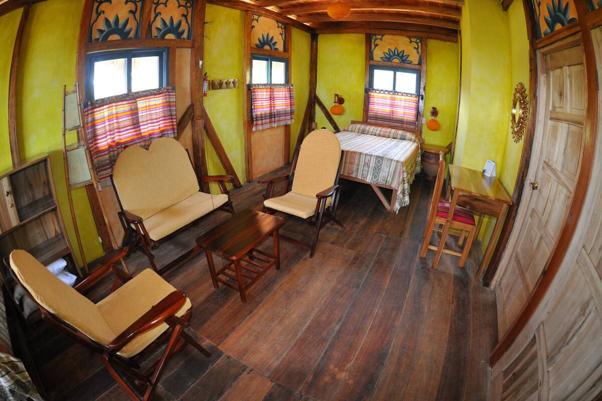 A room with wooden furniture, a table, and a chair.