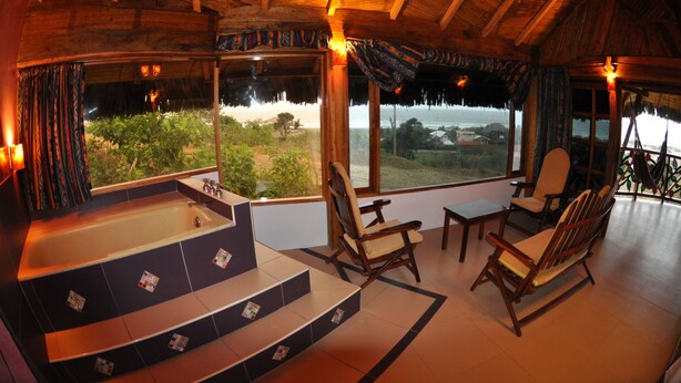 Una habitación con una bañera grande, muebles de madera y vistas al paisaje.