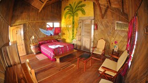 Una habitación con una cama, una silla, una mesa y una puerta.