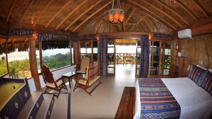 Una habitación amplia con una cama grande, techo de madera y vistas al exterior.
