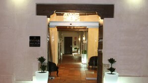 The entrance to the Eviña Alcalá Boutique Hotel with a tiled floor and potted plants on either side. - Evenia Alcalá Boutique Hotel (Alcala de Henares)