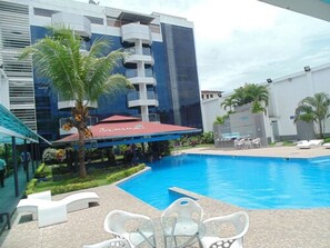 A swimming pool with lounge chairs and a palm tree. - Samiria Jungle Hotel (Belén)