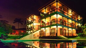 Un edificio de varios pisos con balcones, una piscina y una escalera que conduce a los niveles superiores.
