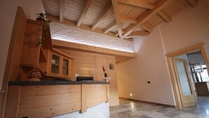 Une cuisine spacieuse dotée de meubles en bois et d’un sol en pierre.