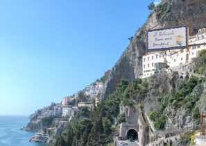 A coastal hotel with a sign advertising room and breakfast, situated on a cliff overlooking the sea. - Il Porticciolo di Amalfi (Amalfi)