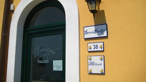 Une entrée d’immeuble avec une enseigne indiquant « Chambre et petit-déjeuner » et le numéro « 38 ».