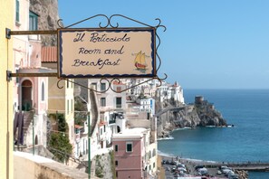 A sign for "Il Porticcio Room and Breakfast" with a view of a coastal town and a lighthouse. - Il Porticciolo di Amalfi (Amalfi)