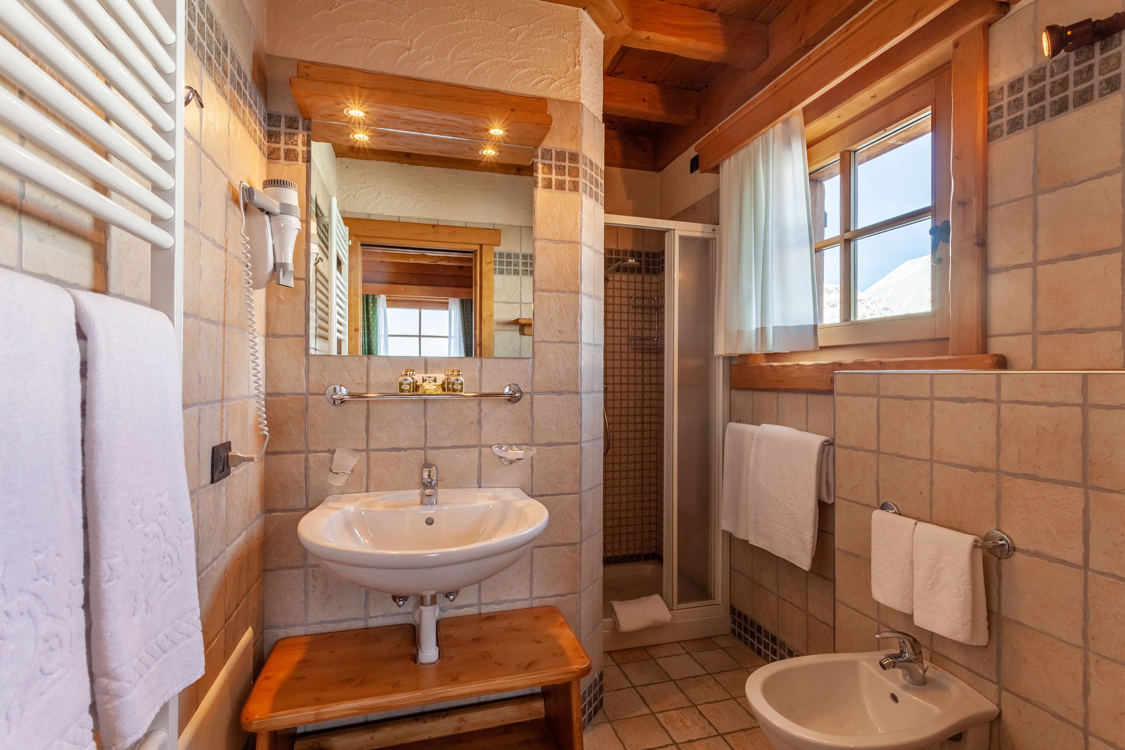 Une salle de bain équipée d’un lavabo, d’un miroir, d’un porte-serviettes et d’une douche.