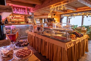 A buffet with various food items and a bar area with bottles. - Park Chalet Village (Livigno)