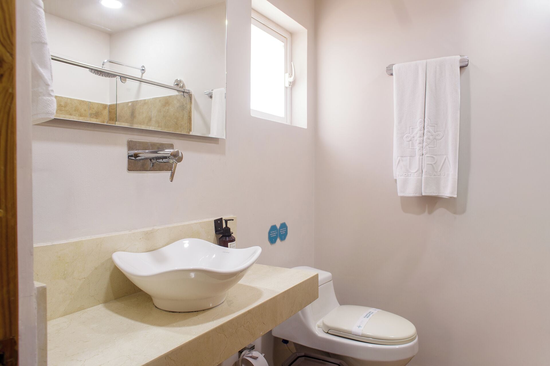 A bathroom with a white sink, a toilet, a towel hanging on a rack, and a shower area.