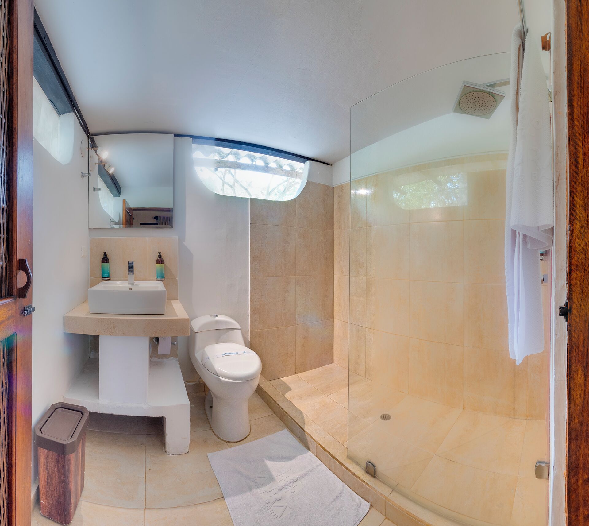 A modern bathroom with a toilet, sink, and shower.