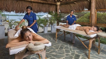 Experience relaxation under a thatched roof, with two massage tables and soothing surroundings.
