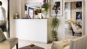 Un moderno vestíbulo de hotel con mostrador de recepción, zona de estar y comedor.