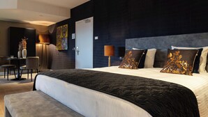 Een moderne hotelkamer met een groot bed, een bureau en een stoel.