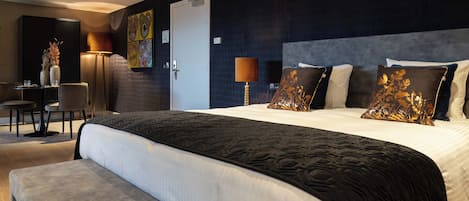 Une chambre d’hôtel moderne avec un grand lit, un bureau et une chaise.