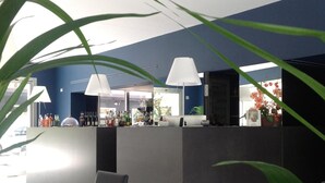 A modern bar area with a counter, bar stools, and a variety of bottles. - Villa Regina (Riva del Garda)