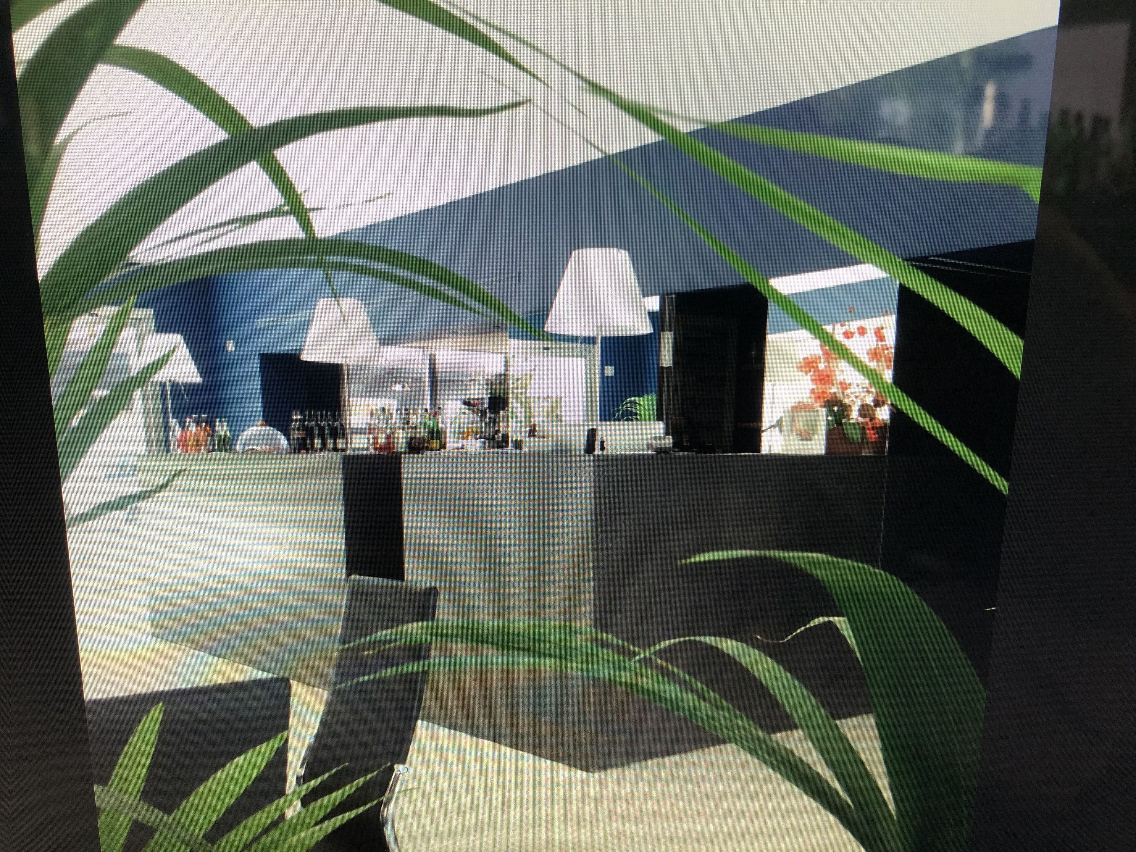 Un interior moderno con una pared azul, una recepción y un área de estar con mesas y sillas.