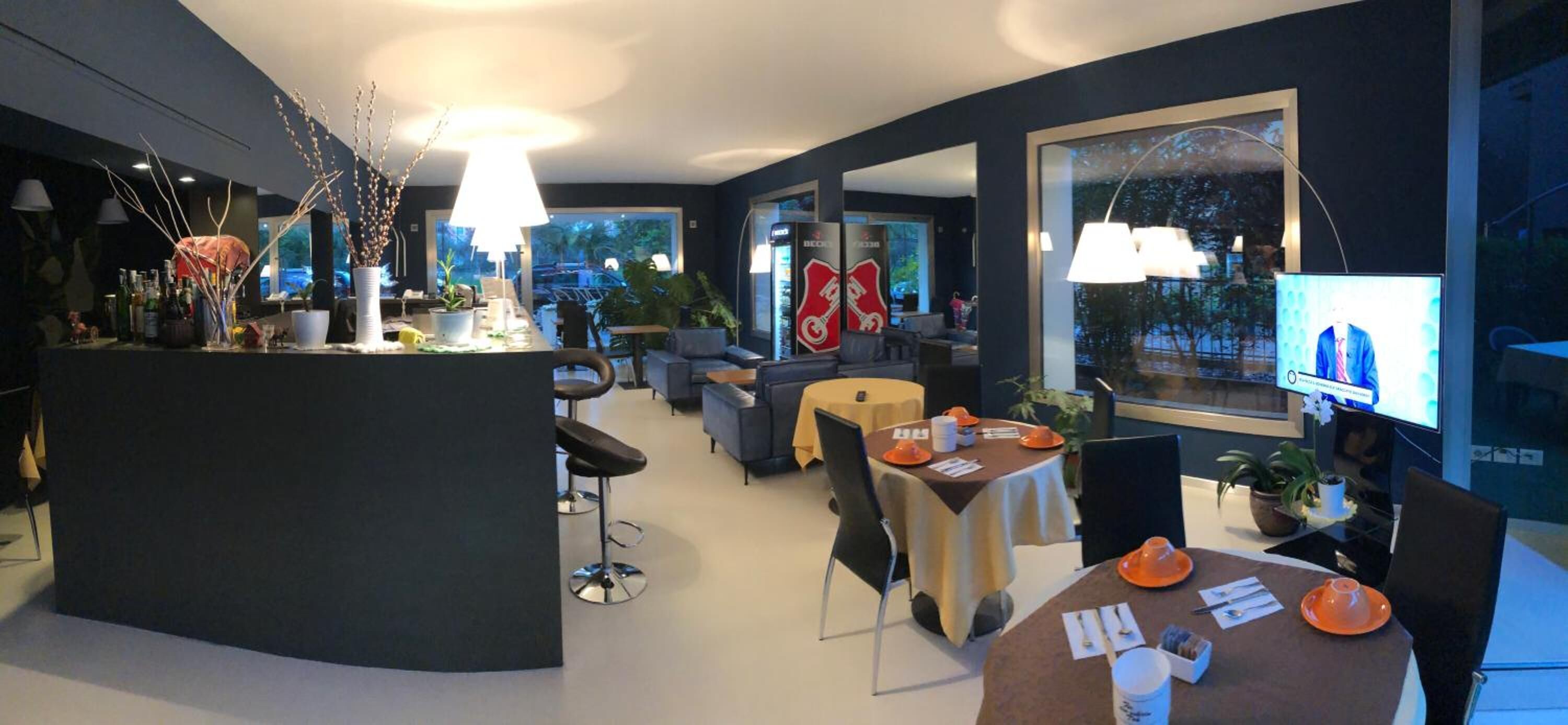 Een modern interieur met een bar in het midden, zitgedeeltes en grote ramen met uitzicht.