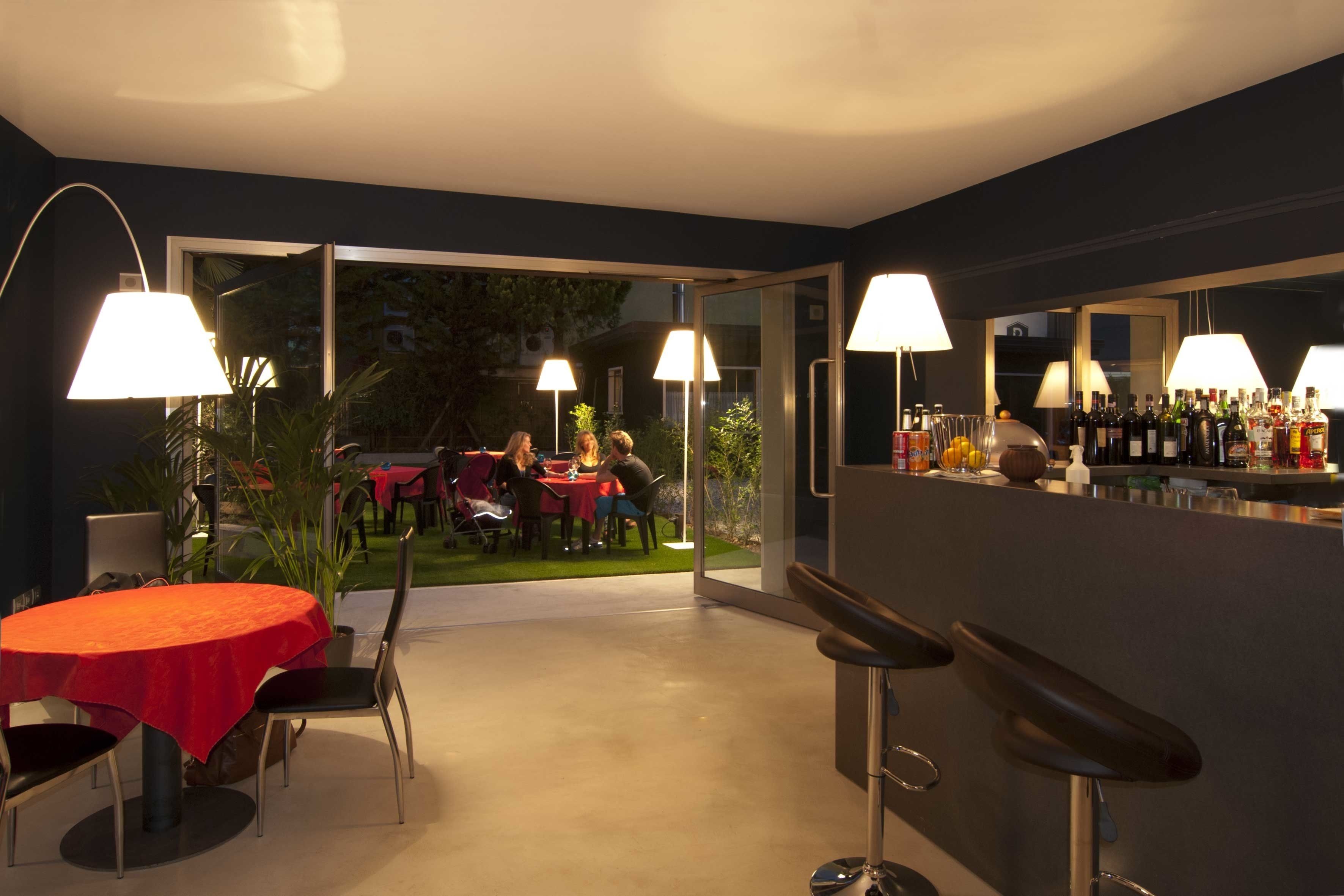 Un espace repas moderne avec une table ronde, des tabourets de bar et un éclairage d’ambiance.
