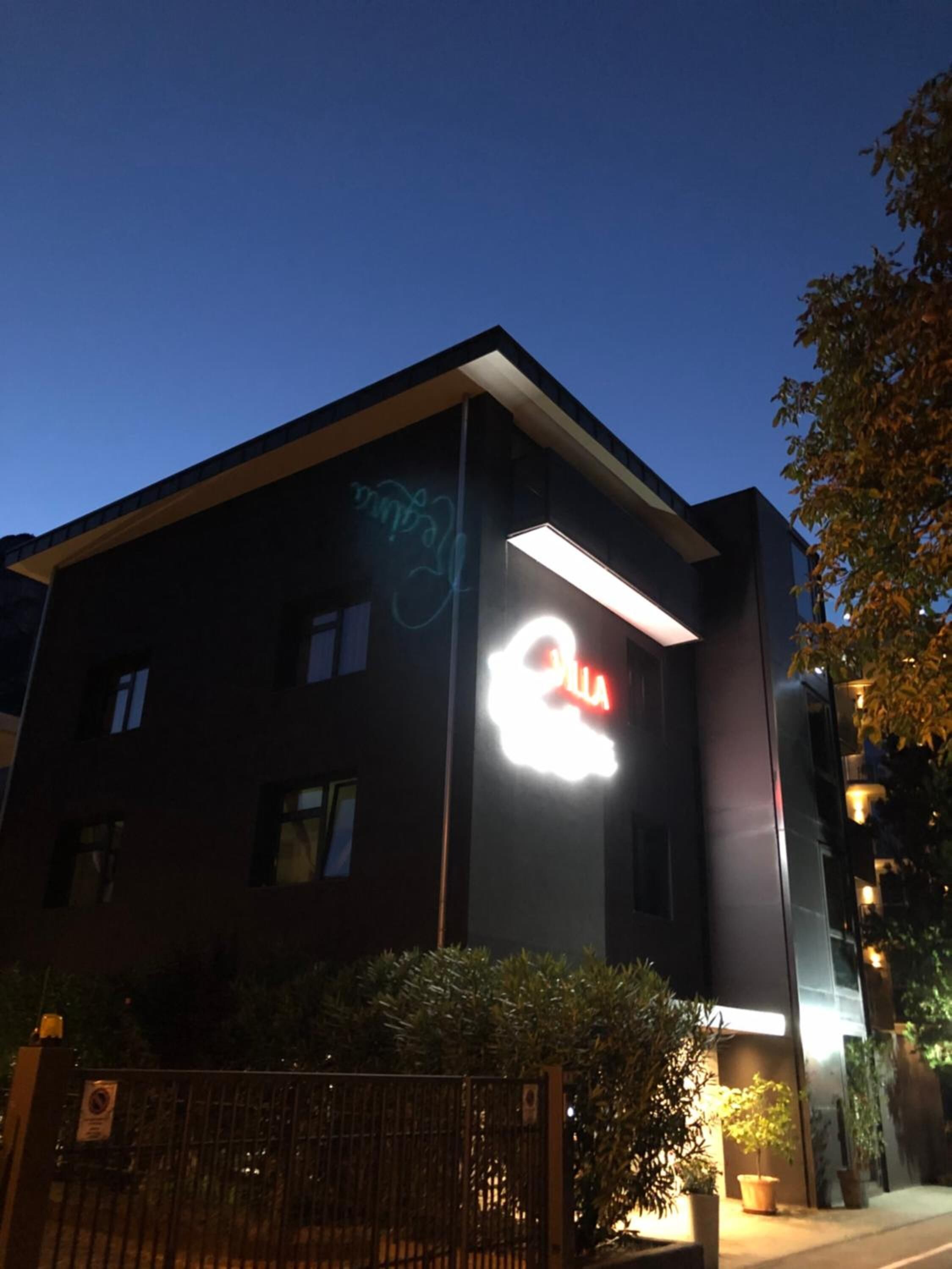 Een modern gebouw met een opvallend verlicht bord waarop 