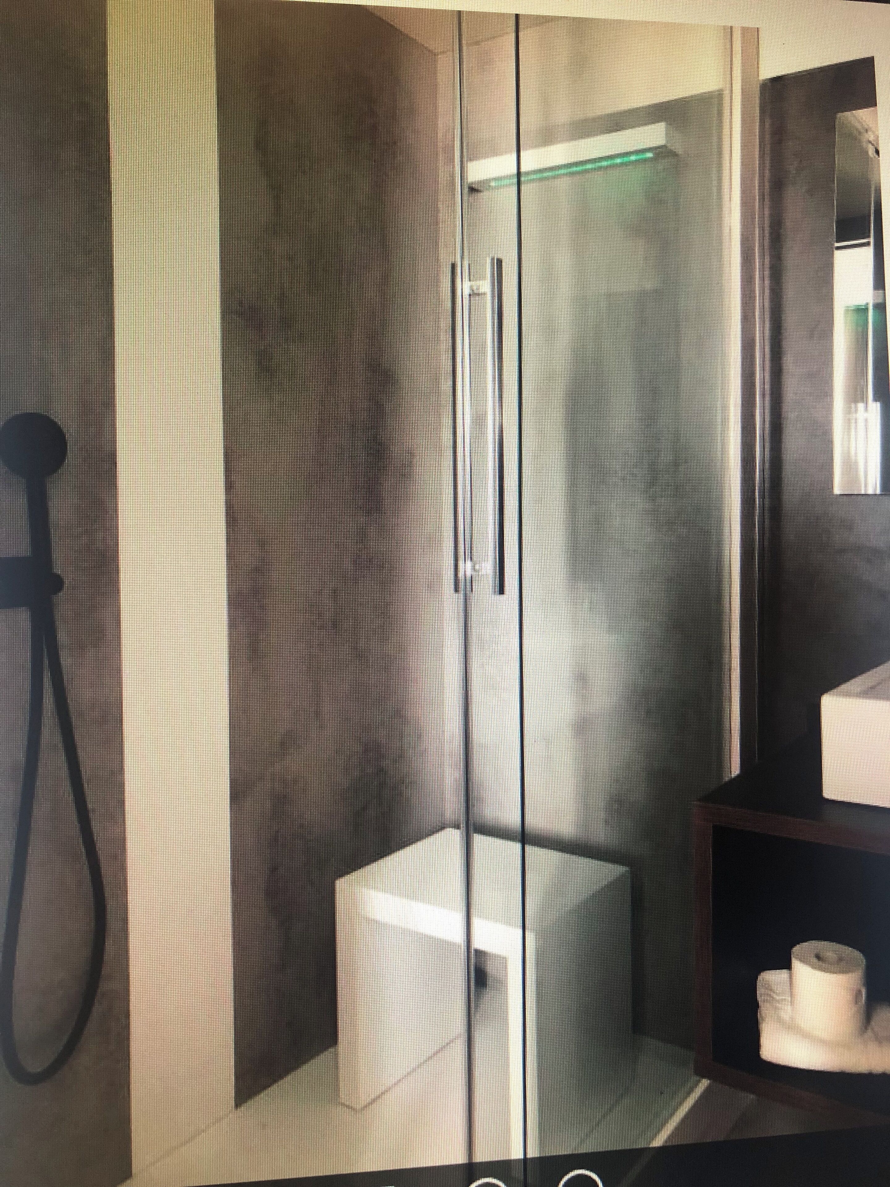A modern bathroom with a glass partition, a shower area, and a toilet.
