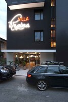 Un edificio moderno con un letrero de neón que dice "Villa Regina".