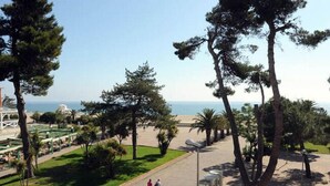 A park with pathways, trees, and a view of the sea. - Hôtel Beau Rivage (Argelès-sur-Mer)