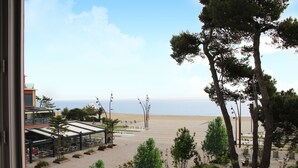 A view of a beachside patio with outdoor seating, trees, and a clear sky. - Hôtel Beau Rivage (Argelès-sur-Mer)