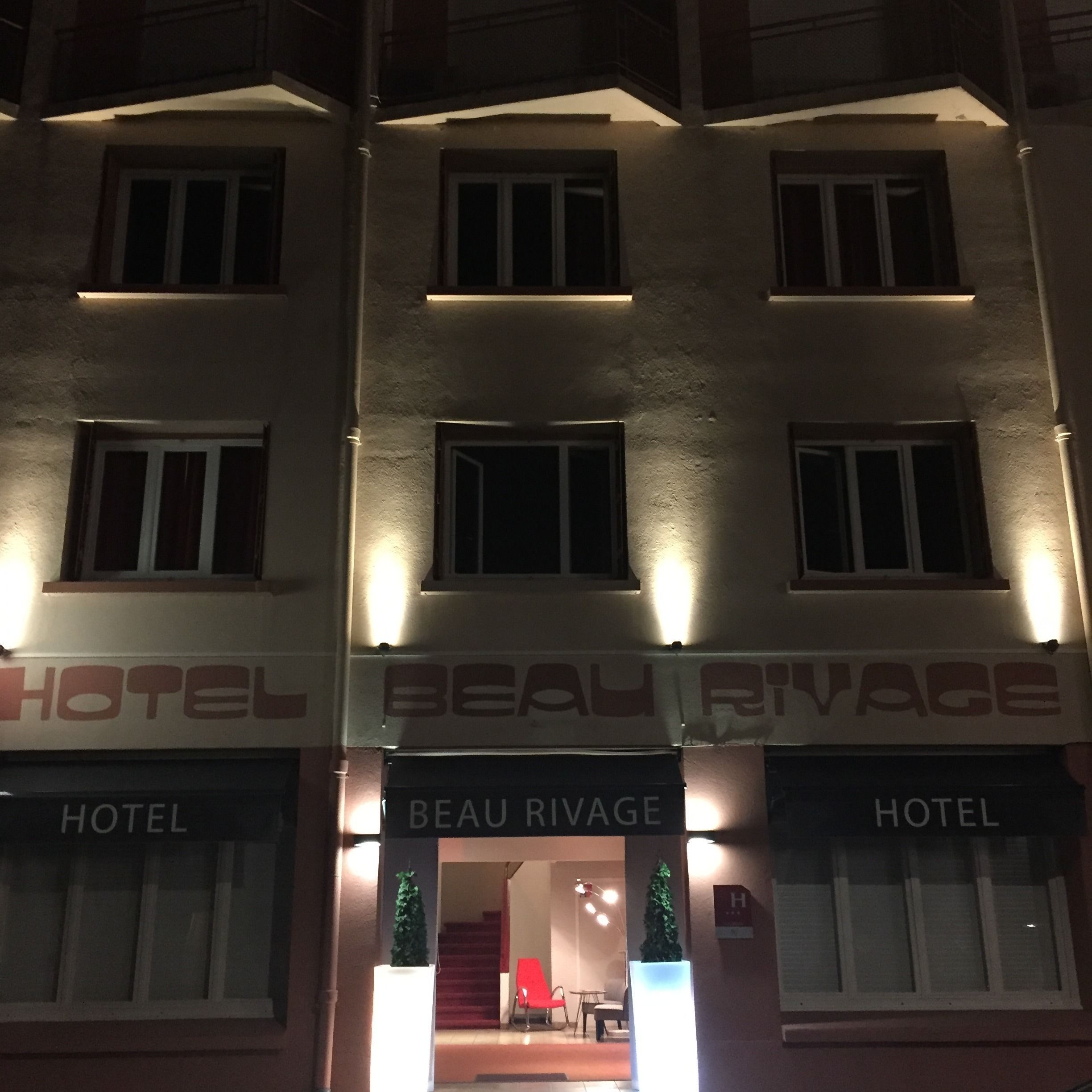 A hotel facade with illuminated signage reading "BEAU RIVAGE HOTEL".
