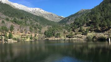 A serene lake surrounded by mountains and dense forests.