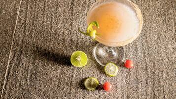 Un verre à cocktail, orné d’une tranche de citron vert, posé sur une surface texturée.