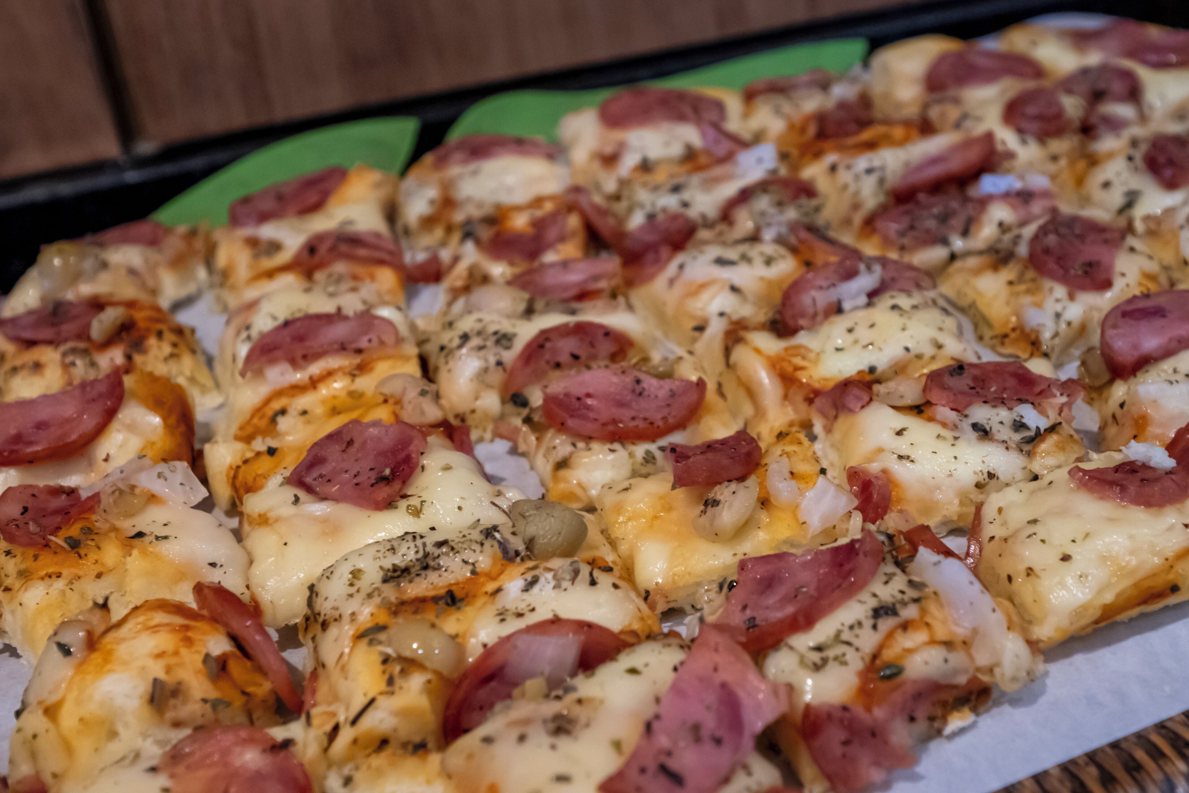 A tray of pizza slices with pepperoni and cheese.