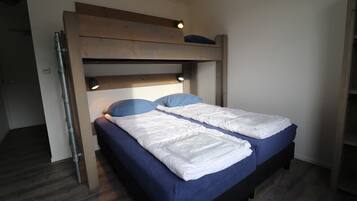 A bunk bed with two beds, each with a blue mattress and white bedding.