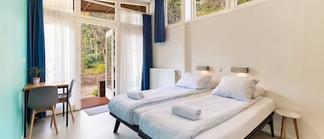 A bedroom with a bed, bedside tables, a desk, and a chair.