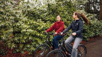 Two individuals on bicycles, surrounded by dense foliage.